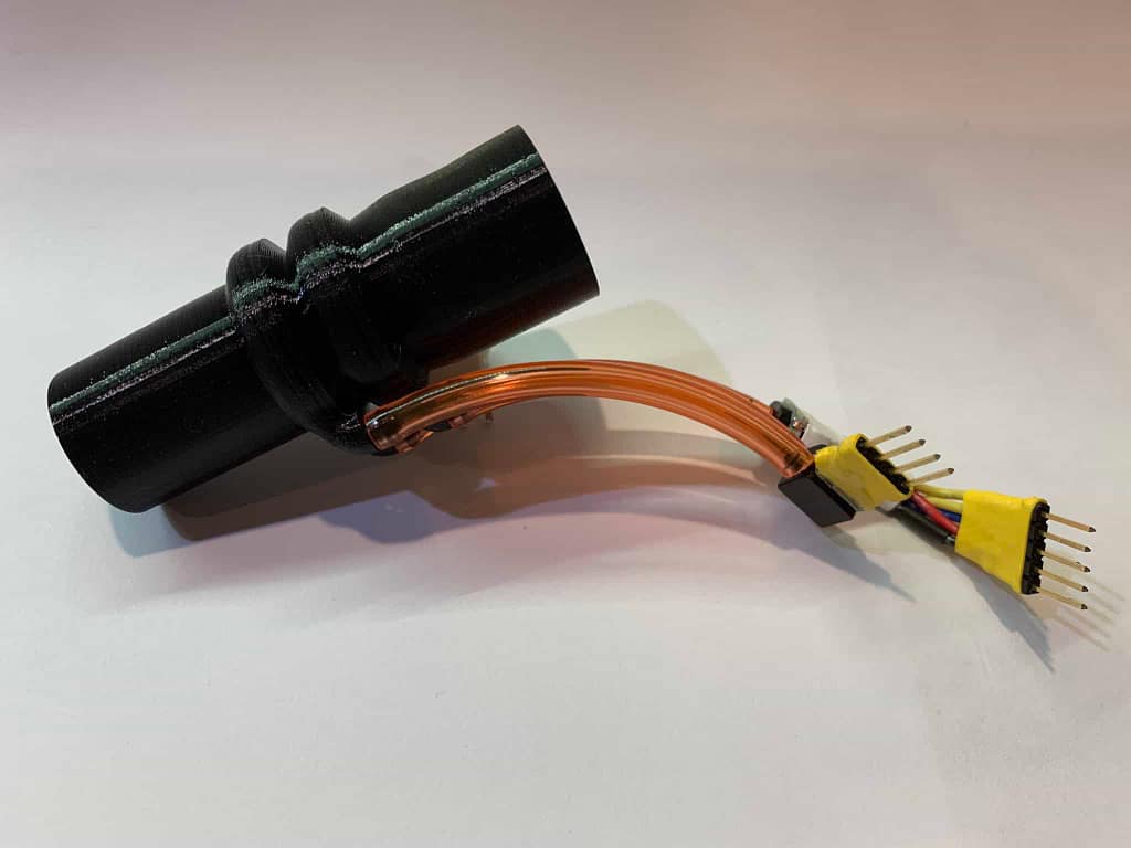 small black fitting with sensors wires connected on the side